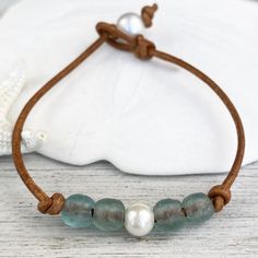 It's time to get out and go to the beach! Beautiful opaque gulf blue sea glass beads on genuine leather will make a unique gift for a loved one or maybe a little something for yourself. A lustrous petite freshwater pearl accents the blue glass with a larger pearl on back for a sliding knot clasp. Each piece of jewelry is handmade to order and ships quickly from the beautiful Panhandle of Florida.Sizes: 6 inches - Small7 inches - Med (most popular)8 inches - Lg9 inches - XLOther: customs sizes av Bohemian Leather Bracelet With Sliding Knot, Casual Beaded Leather Bracelet As A Gift, Blue Beaded Leather Bracelet For Gift, Adjustable Blue Leather Bracelet As Gift, Adjustable Blue Leather Bracelet Gift, Blue Leather Bracelet For Gift, Jewelry For Summer, Pearl Ankle Bracelet, Leather Anklets