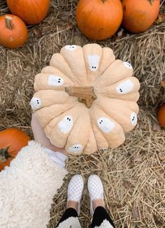 a person standing in front of pumpkins with their feet propped up on the ground