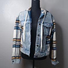 a mannequin wearing a blue jean jacket with plaid sleeves and hoodie on it