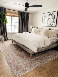 a large bed sitting in the middle of a living room next to a wooden floor