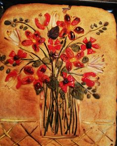 a vase filled with lots of red flowers on top of a pan covered in cake