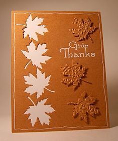 an orange and white greeting card with leaves on it, says give thanks to all of us