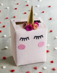 a pink box with a unicorn face and a gold horn on it's head