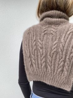 a woman with her back to the camera wearing a sweater