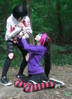 two people dressed as zombies in the woods with one holding an injured woman's head