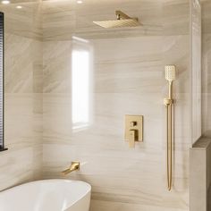 a white bath tub sitting under a window next to a shower head and hand shower faucet