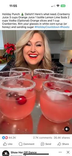 the woman is holding up three glasses with drinks in them