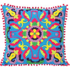 a colorful pillow with pom poms on the bottom and an embroidered design on the front