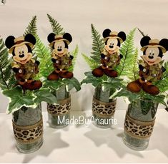 three vases filled with plants and mickey mouse figurines on top of each other