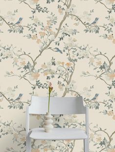 a white chair sitting in front of a wallpaper