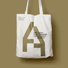 a white tote bag with the number four printed on it, hanging from a wall