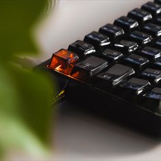 a close up view of a computer keyboard with an orange light on it's side