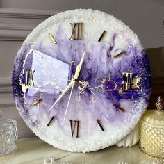 a clock made out of marble with purple and gold accents on it's face