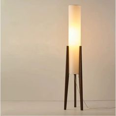 a lamp that is on top of a wooden stand with a white light in the middle