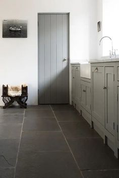 a kitchen with gray cabinets and white walls