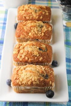 four blueberry muffins on a white plate