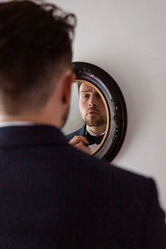 a man is looking at himself in the mirror