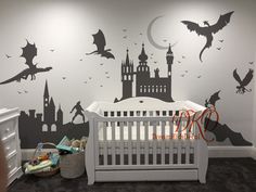 a baby's room with a crib and wall decals on the walls