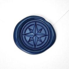 a blue wax seal with a star on it's center is laying on a white surface