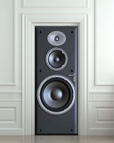 a pair of speakers sitting on top of a floor in front of a white wall