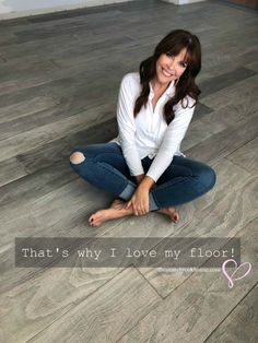 a woman is sitting on the floor with her legs crossed and smiling at the camera