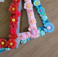 there are flowers in the shape of a letter made out of plastic beads and fake flowers