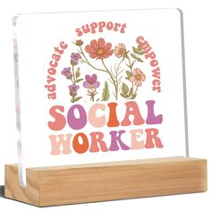 a wooden block with the words social worker printed on it and flowers in pink, purple, yellow and orange