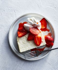 a piece of cake with whipped cream and strawberries on top