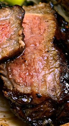 two pieces of meat sitting on top of a cutting board