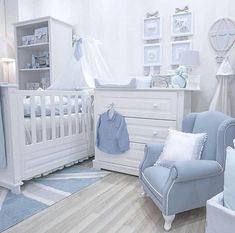 a baby's room with white furniture and blue accessories