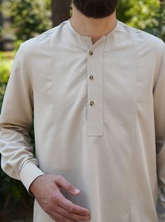 Curved neckline Notched button placket opening Front seams with pleats Buttoned cuffs with pleats Item Code: mQ1921 Model is 184cm (6 feet) and wearing size L Casual Long Sleeve Beige Kurta, Beige Long Sleeve Casual Kurta, Casual Beige Long Sleeve Kurta, Classic Fitted Long Sleeve Kurta, Classic Tops With Stand Collar And Button Cuffs, Classic Tops With Button Cuffs And Stand Collar, Formal Long Sleeve Beige Kurta, Classic Pleated Button-up Top, Long Sleeve Kurta With Button Cuffs For Workwear