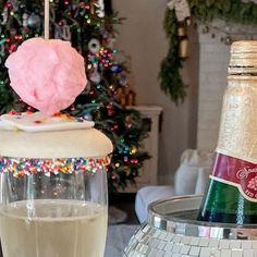 a bottle of champagne next to a glass filled with ice cream and sprinkles