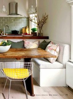 a kitchen table with two chairs and a bench in front of the counter top area