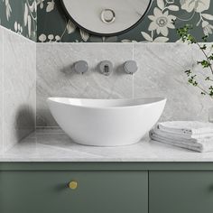 a white bowl sink sitting on top of a counter next to a wall mounted mirror