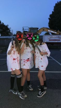 three girls dressed up in costumes with neon lights on their faces and hands are standing together