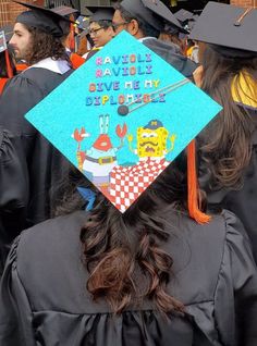 a group of people in graduation gowns and caps with writing on the back of their caps