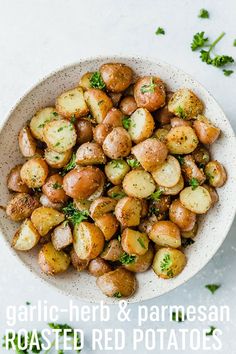 a white bowl filled with potatoes and parsley