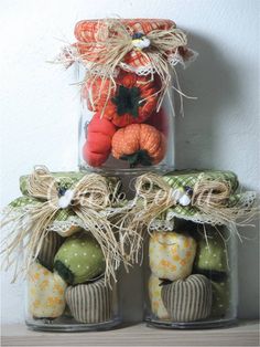 three jars filled with pumpkins and other decorations