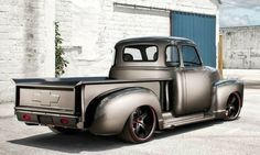 an old silver truck parked in front of a building