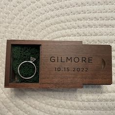 a wooden box with a ring in it that says gitmore on the inside