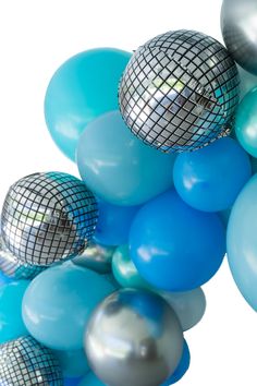 many blue and silver balloons with disco balls on them are floating in the air together