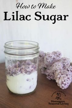 a jar filled with lilac sugar sitting on top of a table next to flowers