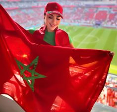 a woman holding a red flag in front of a stadium