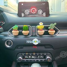 the dashboard of a car with three small cactus decorations on it's dash board