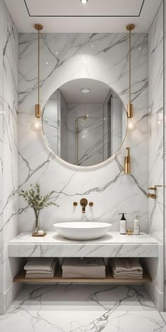 a bathroom with marble walls and white counter tops, gold fixtures and a round mirror above the sink