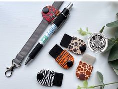 several different animal themed items are laid out on a white surface next to a pen and keychain