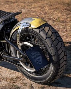 a close up of a motorcycle parked in the dirt