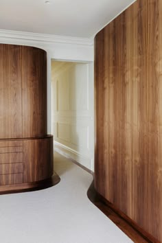 an empty room with wood paneling and white carpet