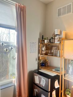 a room with a window, shelves and various items on the shelf next to it