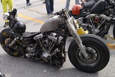 two motorcycles parked next to each other in a parking lot with people looking at them